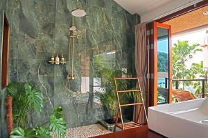 a bathroom with a tub and a shower with plants at Secret Garden Eco Pool Villas in Ko Tao