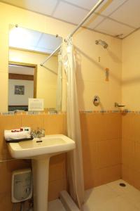 ein Badezimmer mit Waschbecken und Dusche in der Unterkunft Silom Avenue Inn in Bangkok