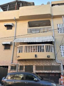 a car parked in front of a building with a balcony at Studio meublé Aéroport cité SIPIM in Abidjan