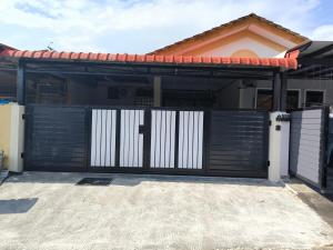 a black and white gate in front of a house at Homestay Idora PD in Port Dickson