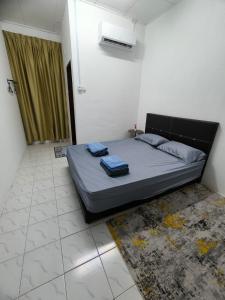 a bedroom with a bed with two towels on it at Homestay Idora PD in Port Dickson