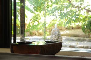 a pair of glasses sitting on a table in front of a window at Taketomijima Akaneya in Taketomi