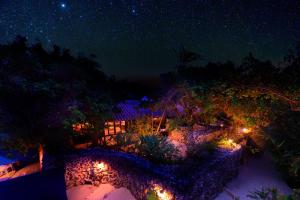 a night view of a garden with lights at Taketomijima Akaneya in Taketomi