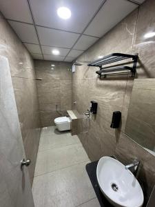 a bathroom with a sink and a toilet at Hotel Crown in Dwarka +17 photos