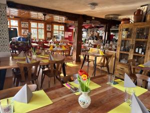 a restaurant with wooden tables and chairs with yellow napkins at Hotel Restaurant Pizzeria Rotes Haus in Münsterlingen