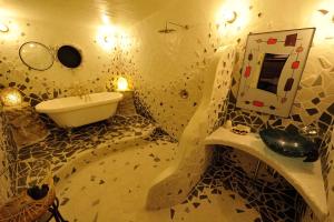 a bathroom with a sink and a tub and a mirror at Taketomijima Akaneya in Taketomi
