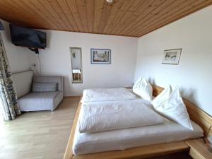 a bedroom with two beds and a tv and a couch at Pension Waldhof in Koppl