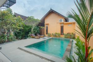 a swimming pool in front of a house at Yessi House in Ubud