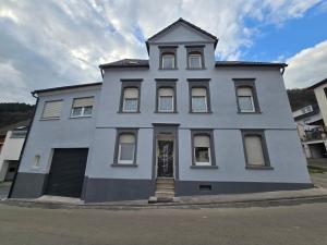 a white building with a statue in front of it at Paula Haus Trier in Trier