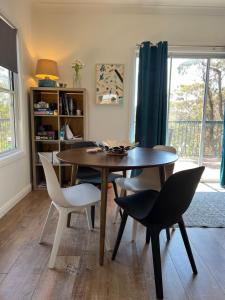 a dining room with a wooden table and chairs at Happy Mountain House in Blackheath +7 photos