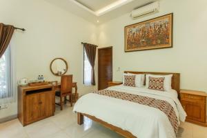 a bedroom with a bed and a desk and a mirror at Yessi House in Ubud