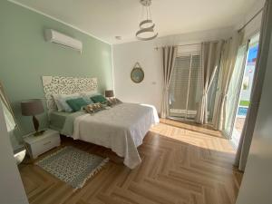 a bedroom with a bed and a large window at Villa Frangipani in Djerba