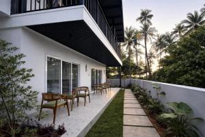 a patio with chairs and tables on a building at The Cove Beach Resort in Cochin