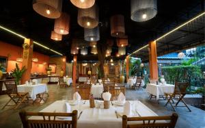 a restaurant with white tables and chairs and lights at Central Indochine d'Angkor Hotel in Siem Reap