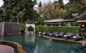 a swimming pool with lounge chairs in a resort at Central Indochine d'Angkor Hotel in Siem Reap