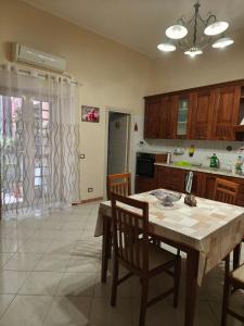 a kitchen with a wooden table and chairs and a table and a table and chairs at Cibali rooms in Catania