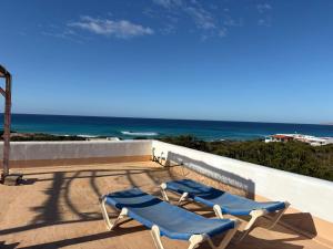 two lounge chairs on a patio overlooking the ocean at Casa Carpe Diem in Es Arenals