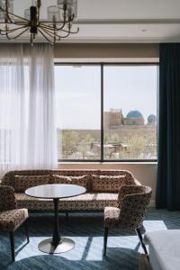 a living room with a couch and two chairs and a table at Medina Palace Hotel in Türkistan