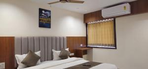 a hotel room with a bed and a window at Hotel Glory in Bavla