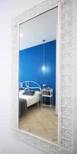 ナポリにあるSebeto Toledoの青い壁の客室で、鏡が備わります。