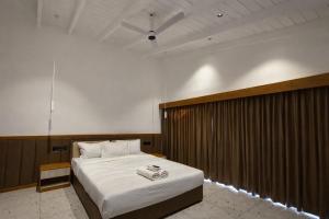 a bedroom with a large bed with white sheets at The Cove Beach Resort in Cochin