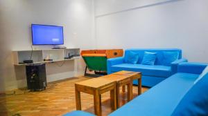 a living room with blue couches and a tv at The Lei's Hotel and Beach Resort in Mercedes +28 photos