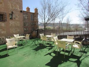 grupa stołów i krzeseł na patio w obiekcie Hotel Real Castillo w mieście Laguardia
