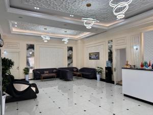 a lobby with couches and tables in a building at Muxlis Hotel in Tashkent
