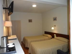 a hotel room with two beds and a desk at Hostal Coruña in Astorga +81 photos