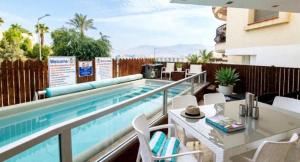 a pool on a balcony with a table and chairs at Amdar Holiday Apartments in Eilat