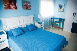 ein blaues Schlafzimmer mit einem Bett und einem Schreibtisch in der Unterkunft Apartments Beach Club in Lloret de Mar