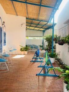a patio with blue chairs and tables and plants at Homestay Đan Sam in Ninh Hải