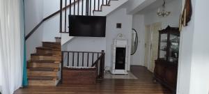 a living room with a staircase with a flat screen tv at Biały Domek in Radęcin