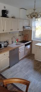 a kitchen with white cabinets and a sink at Biały Domek in Radęcin
