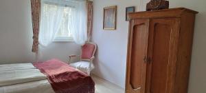 a bedroom with a bed and a dresser and a window at Biały Domek in Radęcin
