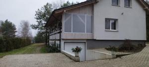 a white house with a large window and a driveway at Biały Domek in Radęcin +9 photos