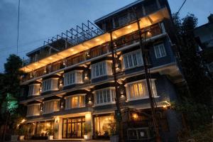 a tall building with lights on it at night at Teesta Hotels, Kalimpong in Kalimpong