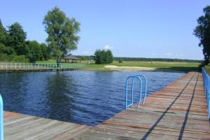 a dock on a lake with a gazebo at Biały Domek in Radęcin