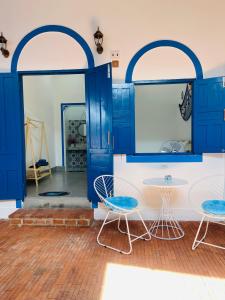 a room with blue doors and two chairs and a table at Homestay Đan Sam in Ninh Hải