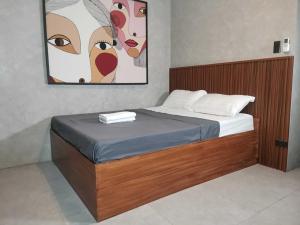 a bedroom with a bed with a painting on the wall at Dancenter Airport Hotel - Grey Hotel in Pampang