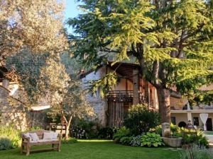a house with a tree and a bench in the yard at Corte del Cedro in Provaglio d'Iseo