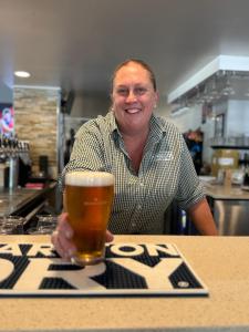 a man sitting at a table with a glass of beer at Amaroo Hotel Dubbo in Dubbo