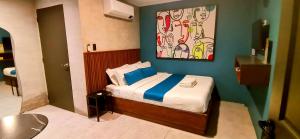 a bedroom with a bed with a painting on the wall at Dancenter Airport Hotel - Grey Hotel in Pampang +19 photos