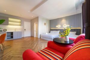 a living room with two beds and a red couch at Golden Suites Saigon in Ho Chi Minh City