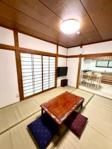 a living room with a wooden table and a television at Mic HANEDA in Tokyo