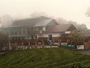 a house on a hill with people in front of it at Heritage Vagamon Cottages in Idukki