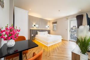 a bedroom with a bed and a table and flowers at Golden Suites Saigon in Ho Chi Minh City