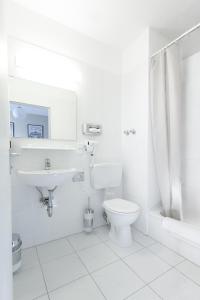 a white bathroom with a toilet and a sink at Happy Hotel Berlin in Berlin +50 photos
