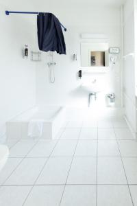 a white bathroom with a sink and a toilet at Happy Hotel Berlin in Berlin