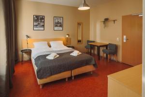 a bedroom with a bed and a table and chairs at Happy Hotel Berlin in Berlin